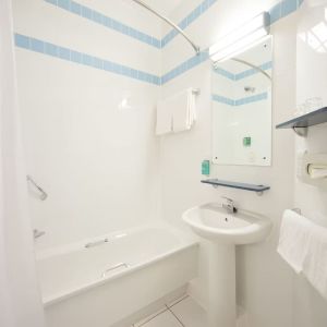 Guest bathroom with shower and tub at Leonardo Hotel Derby.