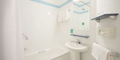 Guest bathroom with shower and tub at Leonardo Hotel Derby.