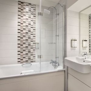 Guest bathroom with shower and tub at Leonardo Hotel Chester.