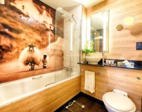 Guest bathroom with shower and tub at Leonardo Royal Hotel Edinburgh Haymarket. 