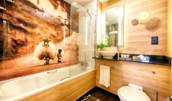 Guest bathroom with shower and tub at Leonardo Royal Hotel Edinburgh Haymarket. 