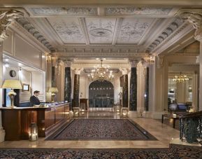 Reception area with elegant architectural details and decorative chandeliers at The Grand Brighton. 