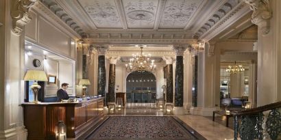 Reception area with elegant architectural details and decorative chandeliers at The Grand Brighton. 