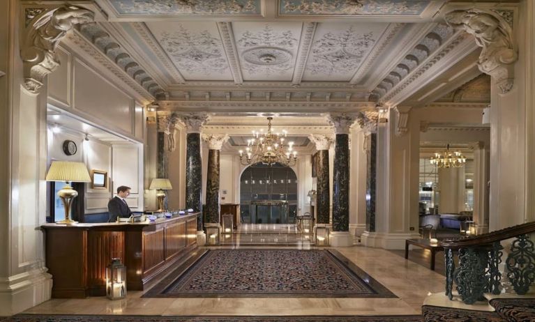 Reception area with elegant architectural details and decorative chandeliers at The Grand Brighton. 