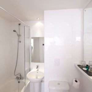 Guest bathroom with shower at Leonardo Inn Glasgow West End. 