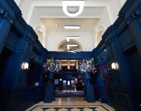 Hotel entrance with bold navy walls and modern hanging letter lights at The Dilly.  