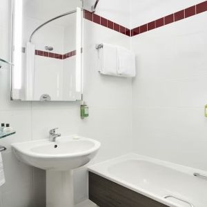 Guest bathroom with shower and tub at Leonardo Hotel Liverpool.