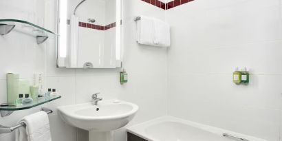 Guest bathroom with shower and tub at Leonardo Hotel Liverpool.