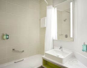 Guest bathroom with shower and tub at Leonardo Hotel Manchester Central.