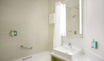 Guest bathroom with shower and tub at Leonardo Hotel Manchester Central.