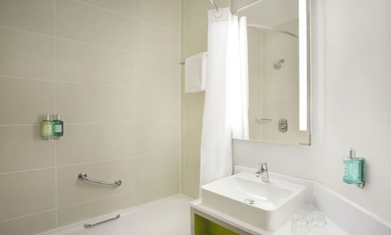 Guest bathroom with shower and tub at Leonardo Hotel Manchester Central.