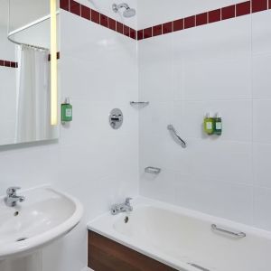 Guest bathroom with shower and tub at Leonardo Hotel Milton Keynes.