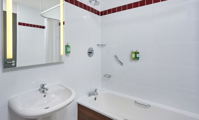 Guest bathroom with shower and tub at Leonardo Hotel Milton Keynes.