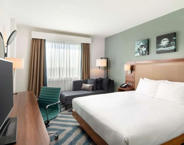 Comfortable delux king room with TV and work desk at Hilton Garden Inn London Heathrow Airport.