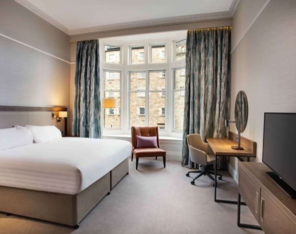 King bedroom with large window at Hilton Edinburgh Carlton.