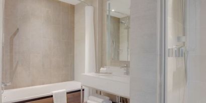 Guest bathroom with shower and tub at Hilton Edinburgh Carlton.