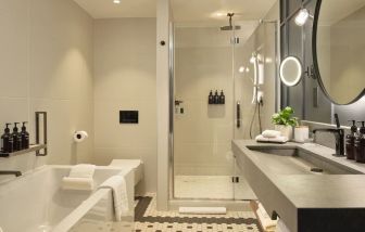 Guest bathroom with shower and tub at The Gantry London, Curio Collection By Hilton.