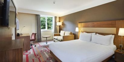 King guestroom with desk and sofa at the DoubleTree by Hilton Newbury North.