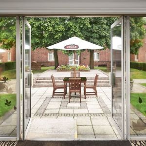 Outdoor patio with chairs, tables and sun umbrellas at the DoubleTree by Hilton Newbury North.