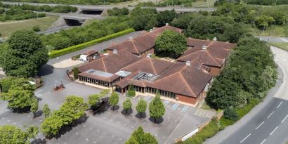 Hotel exterior with green surroundings at the DoubleTree by Hilton Newbury North.