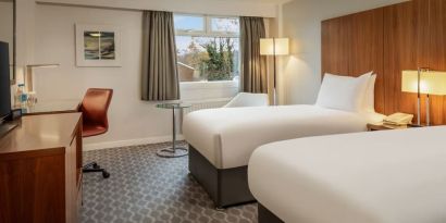 Day use room with double bed, work desk and TV at Hilton London Watford.