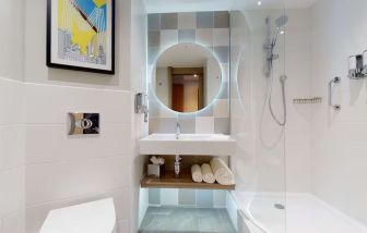 Guest bathroom with shower at the Hampton by Hilton Manchester Northern Quarter.