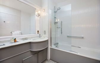 Guest bathroom with shower and tub at DoubleTree By Hilton Coventry.