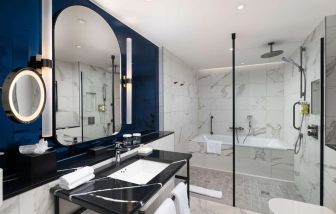 Guest bathroom with shower and tub at Lost Property St. Paul's London, Curio Collection By Hilton.