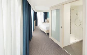 Bright day use room with TV, sofa and private bathroom at the Hampton by Hilton London Docklands.