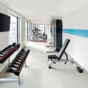 Bright fitness center with machines and equipment at the Hampton by Hilton London Docklands.