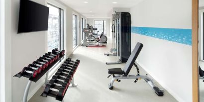 Bright fitness center with machines and equipment at the Hampton by Hilton London Docklands.