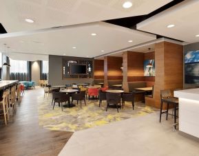 Lobby workspace with tables and chairs at the Hampton by Hilton London Docklands.