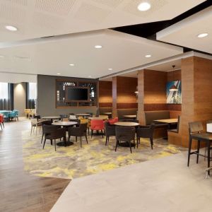 Lobby workspace with tables and chairs at the Hampton by Hilton London Docklands.