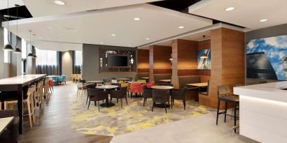 Lobby workspace with tables and chairs at the Hampton by Hilton London Docklands.