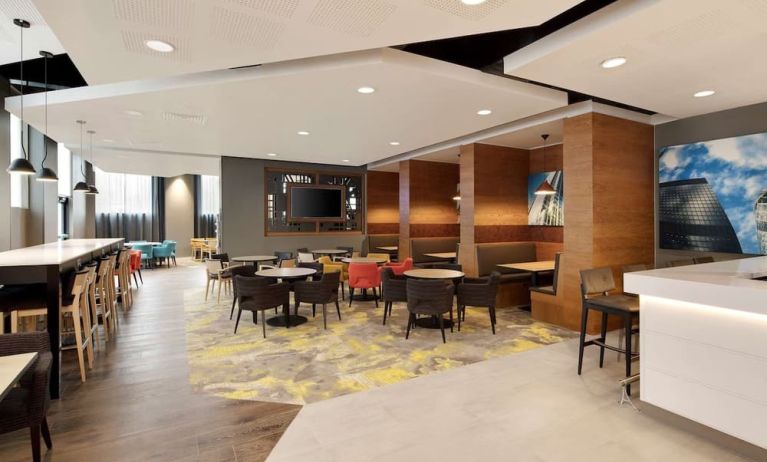 Lobby workspace with tables and chairs at the Hampton by Hilton London Docklands.