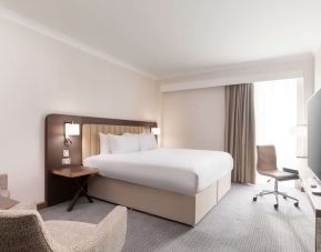 Day use room with work desk and chair, TV and sofa at the Hilton London Gatwick Airport.