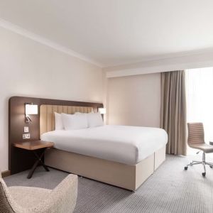 Day use room with work desk and chair, TV and sofa at the Hilton London Gatwick Airport.