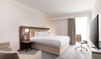 Day use room with work desk and chair, TV and sofa at the Hilton London Gatwick Airport.