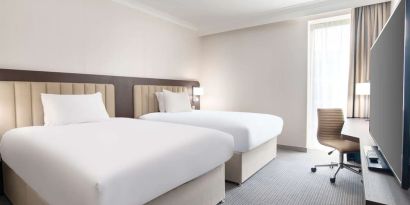 Double guest room with TV screen and desk at the Hilton London Gatwick Airport.