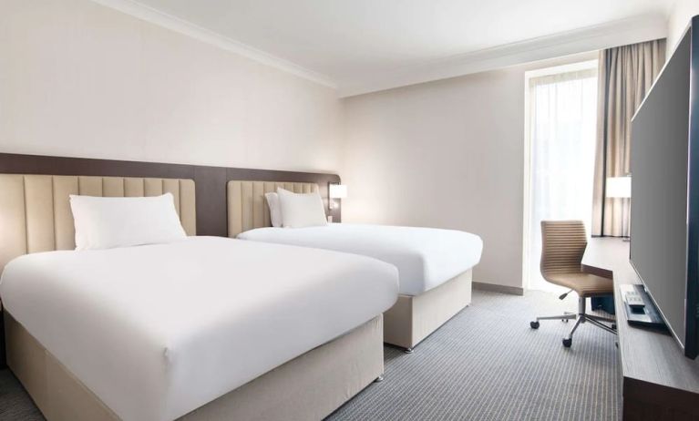 Double guest room with TV screen and desk at the Hilton London Gatwick Airport.