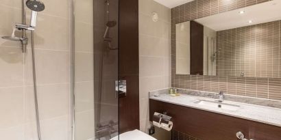 Guest bathroom with shower and free toiletries at the Hilton London Gatwick Airport.