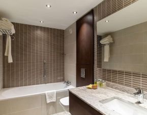 Guest bathroom with tub and free toiletries at the Hilton London Gatwick Airport.