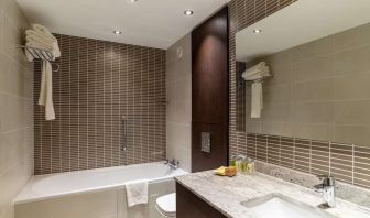 Guest bathroom with tub and free toiletries at the Hilton London Gatwick Airport.