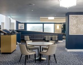 Hotel restaurant with comfortable chairs, perfect for co-working at the Hilton London Gatwick Airport.