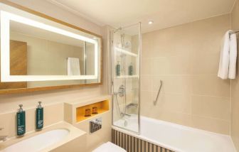 Guest bathroom with shower and tub at DoubleTree By Hilton London - Hyde Park.