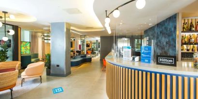 Lobby and coworking lounge at Hampton By Hilton London Park Royal.