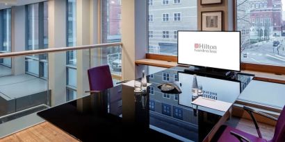 Meeting room with TV and large windows at the Hilton Garden Inn Birmingham Brindleyplace.