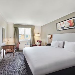 King bedroom with TV screen and desk at the DoubleTree by Hilton Bristol North.