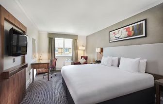 King bedroom with TV screen and desk at the DoubleTree by Hilton Bristol North.