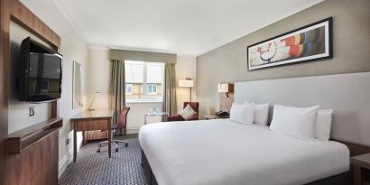 King bedroom with TV screen and desk at the DoubleTree by Hilton Bristol North.